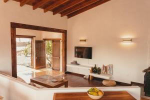 a living room with a television and a table at Casa Maja in Lajares