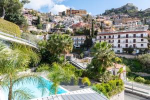 a view of a city with palm trees and buildings at MINERVA LUXURY TOWN CENTER , POOL AND PARKING in Taormina