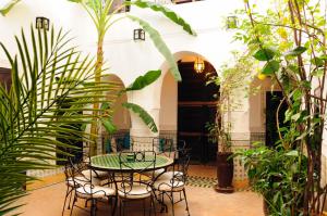 un patio con mesa, sillas y plantas en Riad Al Mamoune en Marrakech