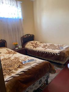 two beds sitting in a room with a window at LoveTatev Bed and Breakfast in Tatʼev
