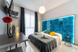 a bedroom with a bed and a blue wall at MINERVA LUXURY TOWN CENTER , POOL AND PARKING in Taormina +21 photos