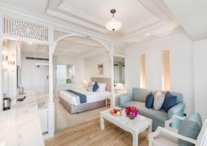 une chambre d'hôtel avec un lit, un canapé et une table dans l'établissement Royal Cliff Beach Hotel Pattaya, à Pattaya (sud)