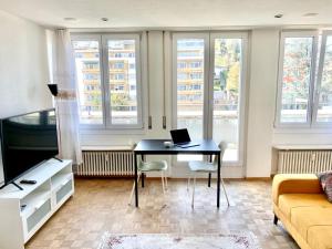 a living room with a table with a laptop on it at Hawa Apartment - two balcony - by PA in Lucerne