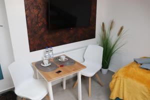 a small table and two white chairs in a room at Apartments Morsum in Thedinghausen