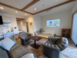 ein Wohnzimmer mit 2 Sofas und einem Tisch in der Unterkunft Rush Awaji - Seaside Holiday Home - Self Check-In Only in Awaji