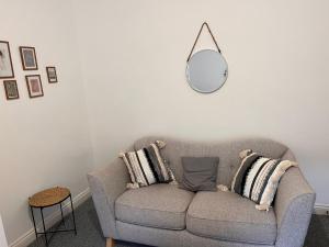 a living room with a gray couch and a mirror at Cosy apartment near Newcastle in Gateshead