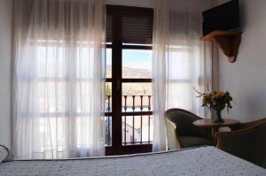 Zimmer mit einem Fenster und Blick auf einen Balkon. in der Unterkunft Hotel El Gamo in Tragacete