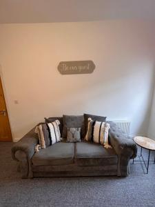 a couch in a living room with a sign that reads be our guest at Cosy apartment near Newcastle in Gateshead