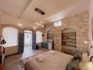 um quarto com uma cama e uma parede de pedra em The Way Inn - Boutique Suites em Safed