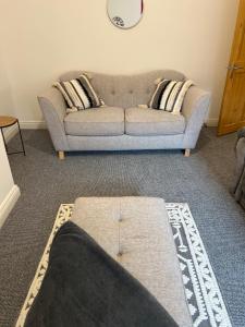 a living room with a gray couch with pillows at Cosy apartment near Newcastle in Gateshead