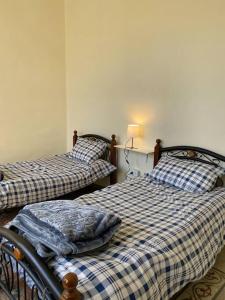 two twin beds in a room with at Central house with beautiful garden in Amman