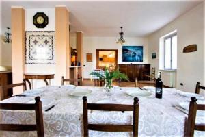comedor con mesa con sillas y reloj en Luxury Private Lunigiana Villa en Bagnone
