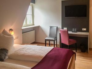 um quarto com uma cama, uma secretária e 2 cadeiras em Torstuben em Tettnang