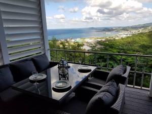 a balcony with a table and chairs and a view of the ocean at CARIBBEAN SPLENDOR WITH MILLION DOLLAR VIEWS in Christiansted
