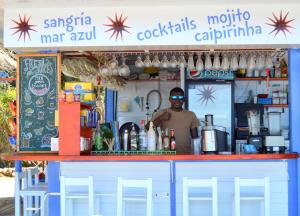 a man standing behind a bar in a food cart at Studios LES TERRASSES de Cala Llevado in Tossa de Mar