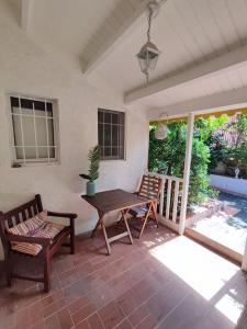 a patio with a wooden table and two chairs at Joli appartement entier sur jardin avec salle d'eau et chambre indépendantes et cuisine équipée in Marigot