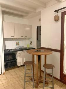 a kitchen with a wooden table and two bar stools at Joli appartement entier sur jardin avec salle d'eau et chambre indépendantes et cuisine équipée in Marigot