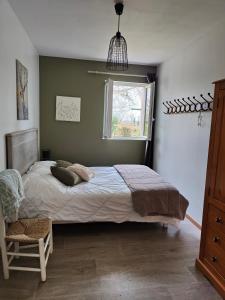 een slaapkamer met een groot bed en een raam bij Le Gîte d'Odette in Dampierre-sous-Bouhy