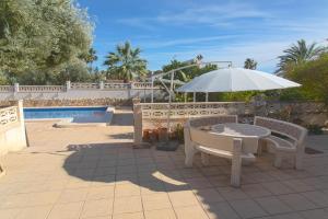 布索特的住宿－Villa Reyets 4 bed 3 bath Private Pool，一个带桌子和遮阳伞的庭院和一个游泳池