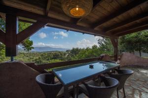 einen Tisch und Stühle auf einer Veranda mit Aussicht in der Unterkunft Hotel Les Hauts de Porto-Vecchio in Porto-Vecchio
