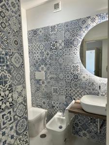 a bathroom with blue and white tiles on the wall at Puglia Dreaming seaview apartment in Polignano a Mare +32 photos