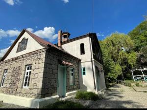 - un vieux bâtiment en pierre avec une porte verte dans l'établissement Legend of Dilijan 1894, à Dilidjan