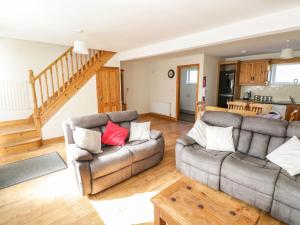 a living room with two couches and a table at Ring Fort Cottage in Longford