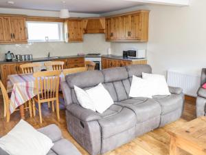sala de estar con sofá y cocina en Ring Fort Cottage, en Longford