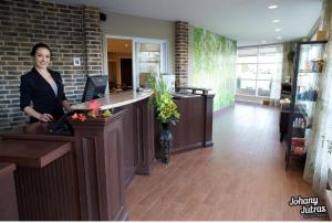 a woman standing at a counter in a salon at Hotel-Motel Drummond in Drummondville