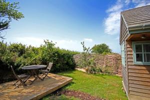 een patio met een tafel en stoelen in een tuin bij Tiny House on isolated farm by the Cornish Coast in Bude