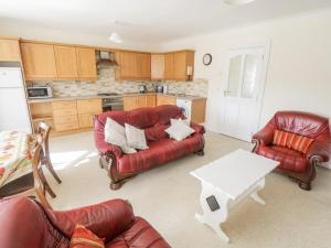 una sala de estar con muebles de cuero rojo y una mesa. en Pine View, Longford, en Longford