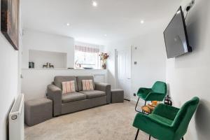 uma sala de estar com um sofá e duas cadeiras verdes em Castle Properties: The Duchess, 3 Bed Family cottage em Windsor