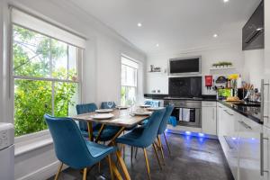 cocina con mesa de madera y sillas azules en Castle Properties: The Duchess, 3 Bed Family cottage, en Windsor