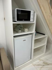 een witte kast met een magnetron en een koelkast bij Apartement en maison proche gare 5 minutes à pied in Dreux