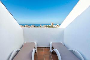 a balcony with two chairs and a view of the ocean at Paradise Park Fun Lifestyle Hotel in Los Cristianos
