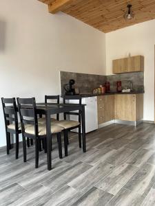 a dining room table with chairs and a kitchen at Merida Residence in Bran