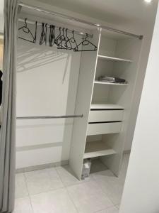a walk in closet with white cabinets and shelves at Chez Julie petit appartement une chambre rez jardin maison in Tulle