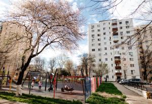 a playground in a park with people playing on it at Carla's Apart Palas-Hala Centrala 1 Bedroom - shuttle in Iaşi