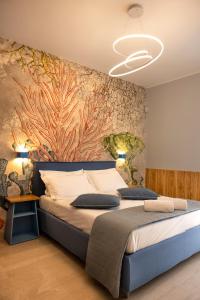 Schlafzimmer mit einem Bett mit Wandgemälde in der Unterkunft Dimora Lauro in Gagliano del Capo