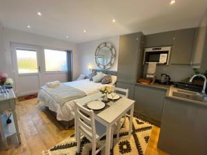 a bedroom with a bed and a table and a kitchen at Beautiful 1-Bed studio in Penrith in Penrith