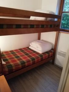 Łóżko piętrowe w niewielkim pokoju z pościelą piętrowym w obiekcie Appartement les chalets d estives w mieście Cauterets