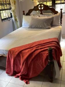 a large bed with a red blanket on it at Beverly's Place in New Amsterdam