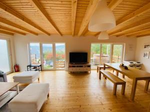 a living room with a table and a flat screen tv at Chata Cérov in Púchov