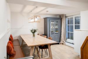 uma sala de jantar com uma mesa de madeira e cadeiras em CAPRINO Guesthouse em Knokke-Heist