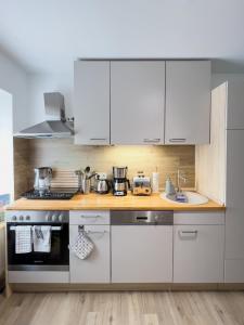 a kitchen with white cabinets and a stove at Schöne helle & gemütliche Wohnung in Altstadtnähe in Erfurt