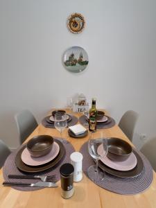 a wooden table with plates and wine glasses on it at Schöne helle & gemütliche Wohnung in Altstadtnähe in Erfurt