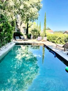 una piscina de agua azul en un patio en Maison avec piscine à Lacoste en Lacoste