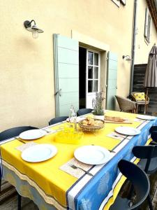 uma mesa com uma toalha de mesa amarela e azul em Maison avec piscine à Lacoste em Lacoste