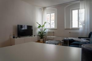 ein Wohnzimmer mit einem Tisch und einem TV in der Unterkunft Altstadtjuwel Liboria in Augsburg
