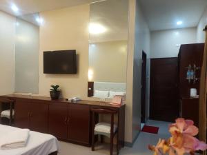 ein Badezimmer mit einem Waschtisch mit einem Spiegel und einem Waschbecken in der Unterkunft B&S Orchids suites hotel in Dipolog City